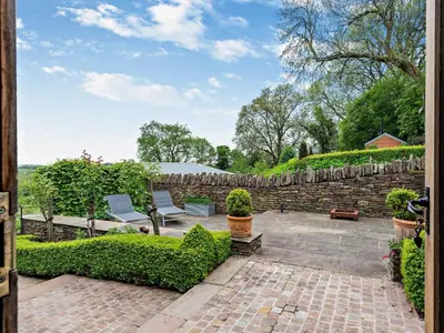 a garden with two chairs and a stone wall at 2 Bed in Hereford oc-42881 in Craswall