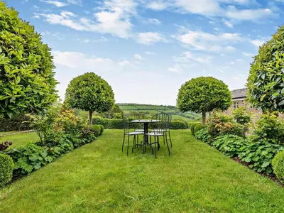 a table and chairs in the grass in a garden at 2 Bed in Hereford oc-42881 in Craswall