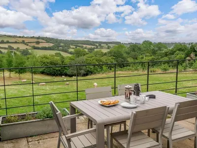 a table and chairs on a balcony with a view of a field at 1 Bed in Hereford oc-42897 in Craswall