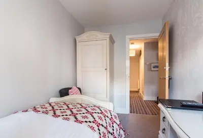 a bedroom with a bed with a red and white blanket at Maes Bach Boutique GUEST HOUSE TOWN CENTRE in Aberystwyth