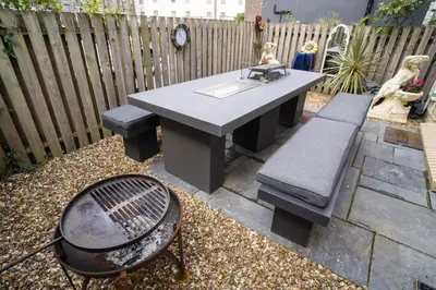 a picnic table and a grill in a backyard at Maes Bach Boutique GUEST HOUSE TOWN CENTRE in Aberystwyth