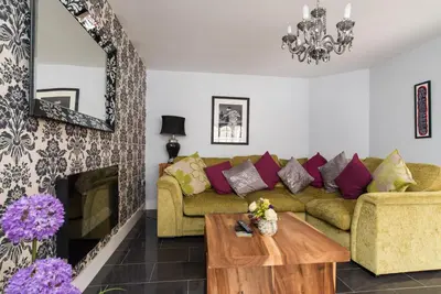 a living room with a couch and a fireplace at Maes Bach Boutique GUEST HOUSE TOWN CENTRE in Aberystwyth