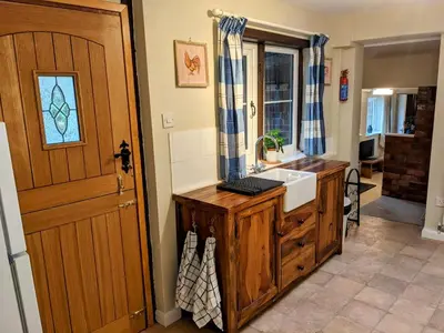a bathroom with a sink and a wooden door at The Byre in Yeaton