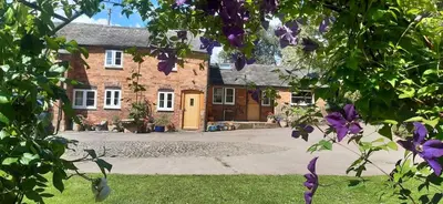 a large brick house with a driveway in front of it at The Byre in Yeaton
