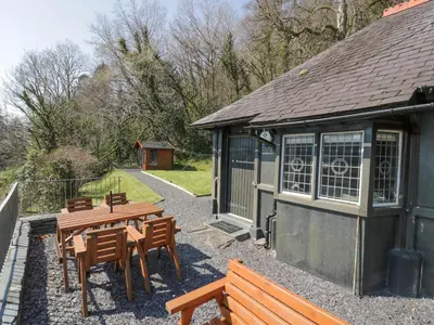 a patio with tables and chairs and a building at Bwthyn y Coediwr The Woodcutters Cottage in Blaenau-Ffestiniog