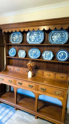 a wooden cabinet with blue and white plates on it at Y Fedw Wen in Bont Newydd