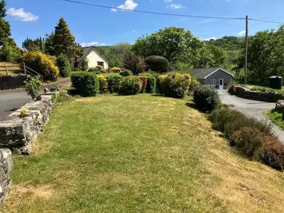 a yard with nicely landscaped bushes and a road at Y Fedw Wen in Bont Newydd