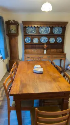a dining room with a wooden table with chairs at Y Fedw Wen in Bont Newydd