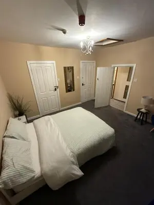 a bedroom with a large white bed in it at Dine & Rest, 1 bedroom apartment at little India in Llanrhaeadr-ym-Mochnant