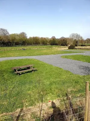 a picnic table in a field next to a road at Green Dragon and Kitchen Pod - Sleeps 2 & Parking in Welshpool