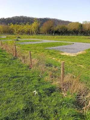 a fence in the middle of a field with a road at Green Dragon and Kitchen Pod - Sleeps 2 & Parking in Welshpool