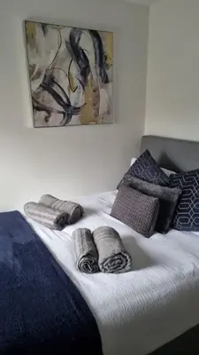 a bed with towels and pillows on top of it at No 3 Waterloo Place in Welshpool