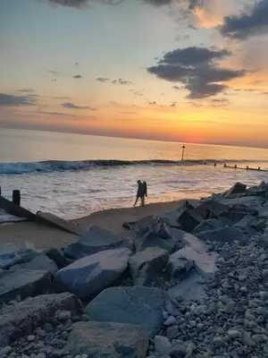 a person walking on the beach at sunset at 254 Bryn y Mor in Tywyn