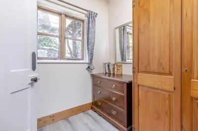 a room with a dresser and a window and a wooden door at 1 Bed in Llwyngwril oc-a31970 in Llwyngwril