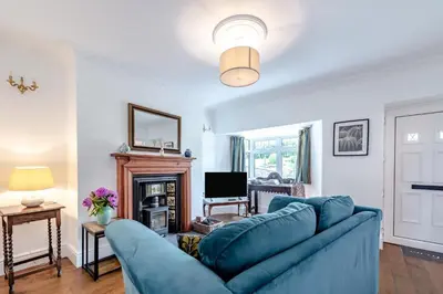 a living room with a blue couch and a fireplace at 1 Bed in Brynteg oc-g32079 in Llanwenog
