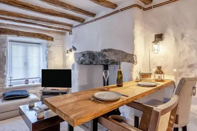 a dining room with a wooden table and a couch at 1 Bed in Harlech oc-t32043 in Harlech