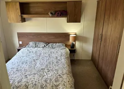 a bedroom with a bed with a wooden head board at The Bay Pearl 2 Bedroom Elegant Pet Free Stay at Clarach in Aberystwyth