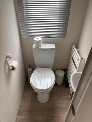 a small bathroom with a toilet and a sink at The Bay Pearl 2 Bedroom Elegant Pet Free Stay at Clarach in Aberystwyth