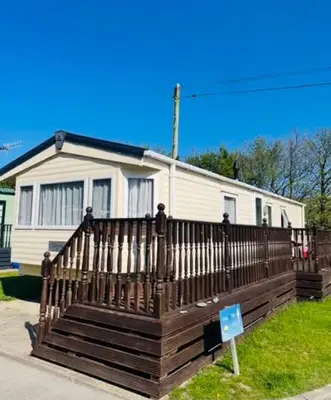 a house with a wooden fence in front of it at The Bay Pearl 2 Bedroom Elegant Pet Free Stay at Clarach in Aberystwyth