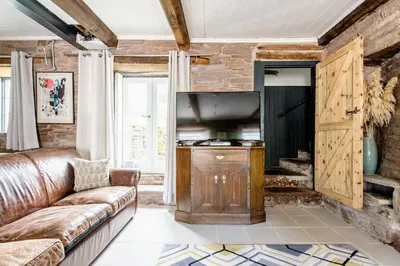 a living room with a couch and a kitchen at 4 bedroom farmhouse Brecon Beacons in Talgarth