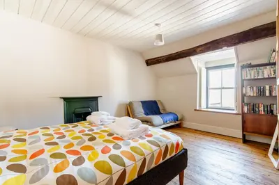 a bedroom with a bed and a chair and a window at 4 bedroom farmhouse Brecon Beacons in Talgarth