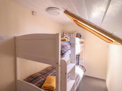 a bedroom with two bunk beds in a room at Glan Y Mor Borth in Aberystwyth