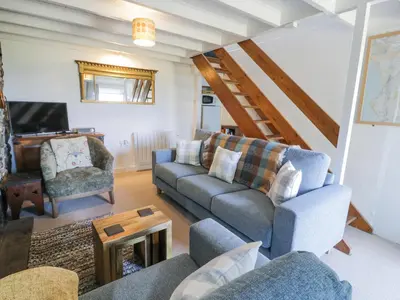 a living room with two couches and a tv at Pen Y Bryn Bach in Harlech
