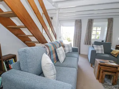 a living room with two blue couches and a table at Pen Y Bryn Bach in Harlech