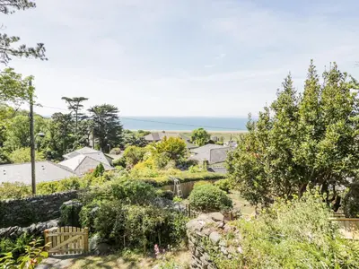 a garden with the ocean in the background at Pen Y Bryn Bach in Harlech