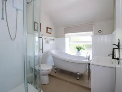 a bathroom with a tub and a toilet and a sink at Pennal Cottage in Oswestry