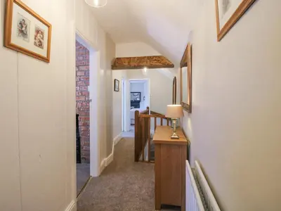 a hallway of a home with a brick wall at Pennal Cottage in Oswestry