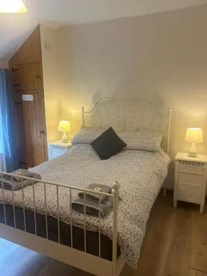 a bedroom with a bed with two night stands and two lamps at Llwyn Celyn 2 bedroom in Bala