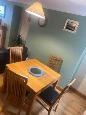a wooden table with chairs and a plate on it at Llwyn Celyn 2 bedroom in Bala