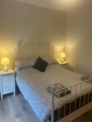 a bedroom with a bed with two night stands and two lamps at Llwyn Celyn 2 bedroom in Bala