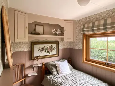 a small bedroom with a bed and a window at The Meadow Snug in Baschurch