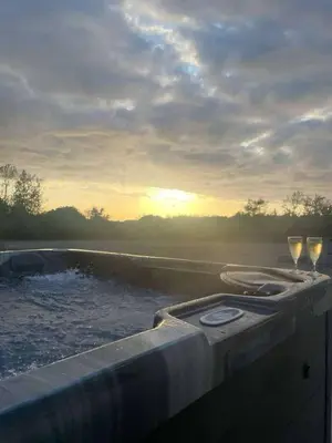 two glasses of wine sitting on the edge of a pool at Cottage in Synod Inn with Hot Tub in Synod