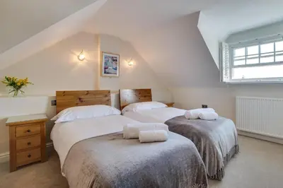 a attic bedroom with two beds and a window at 2 Bed in Aberaeron oc-bow173 in Aberaeron