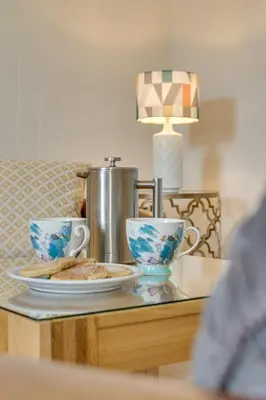 a table with two cups and plates of food at 2 Bed in Aberaeron oc-bow173 in Aberaeron