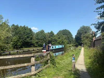 a boat on a canal next to a fence at 5 Metre 'UNFURNISED' Bell Tent in Ball