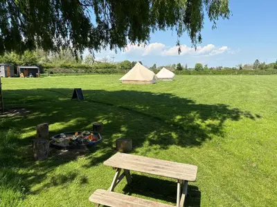 a bench sitting under a tree next to a tent at 5 Metre 'UNFURNISED' Bell Tent in Ball