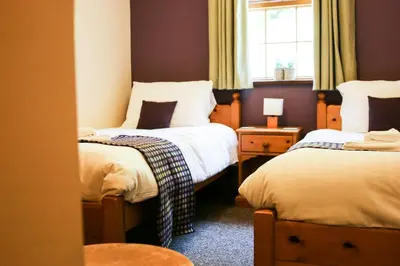 a room with two beds and a window at Y Dderwen Aberaeron in Llanarth
