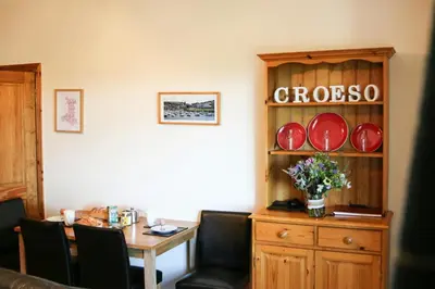 a dining room with a table and plates on a shelf at Yr Onnen Aberaeron in Llanarth
