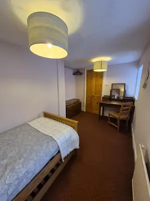 a bedroom with a bed and a desk and a table at Forden House in Dolgellau