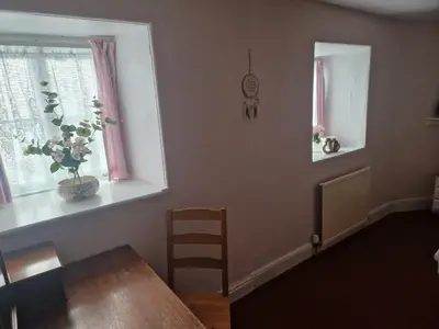 a dining room with a table and a chair and a window at Forden House in Dolgellau