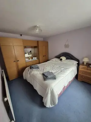 a bedroom with a large bed and wooden cabinets at Forden House in Dolgellau