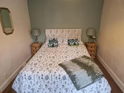 a bed in a bedroom with two nightstands and two lamps at Forden House in Dolgellau