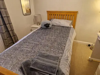 a bed with a stuffed animal sitting on top of it at Forden House in Dolgellau