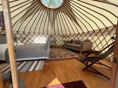 a bedroom in a yurt with a bed and a chair at Hinton land glampsite in Peterchurch