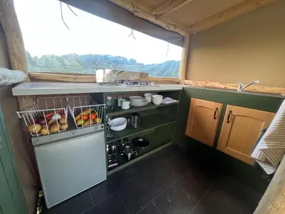 a small kitchen with a sink and a refrigerator at Hinton land glampsite in Peterchurch