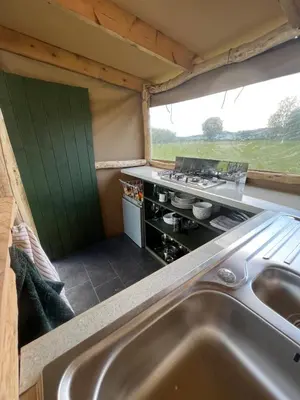 a kitchen with a sink in a tiny house at Hinton land glampsite in Peterchurch